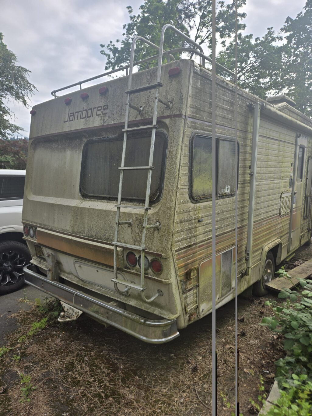 Vintage Fleetwood Jamboree Class C motorhome rear exterior showing ladder and recycling potential.